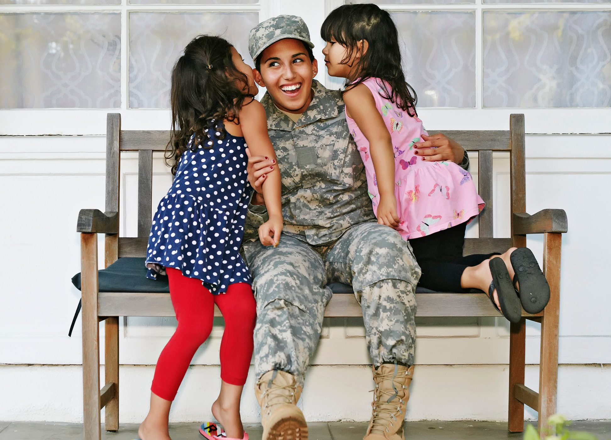 veteran sitting on a bench with their two kids